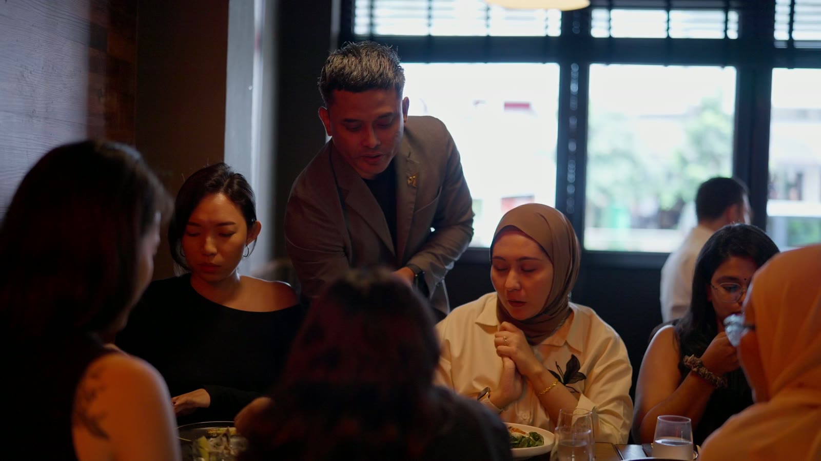 A host greeting guests at their table in the ASAP & Co. dining room