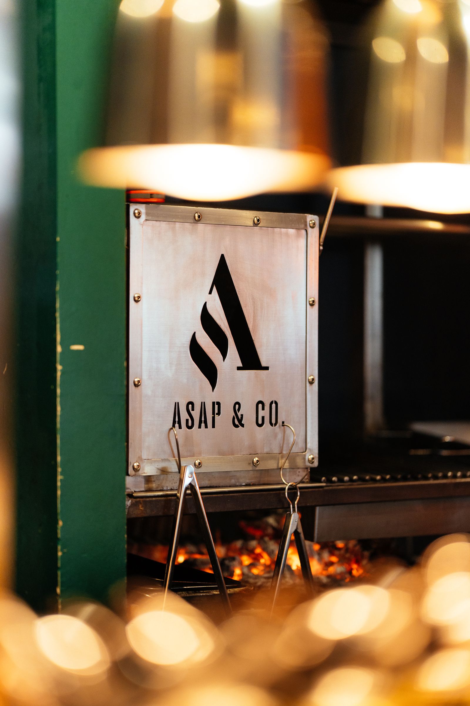 The open wood-fired grill behind the ASAP & Co. plate