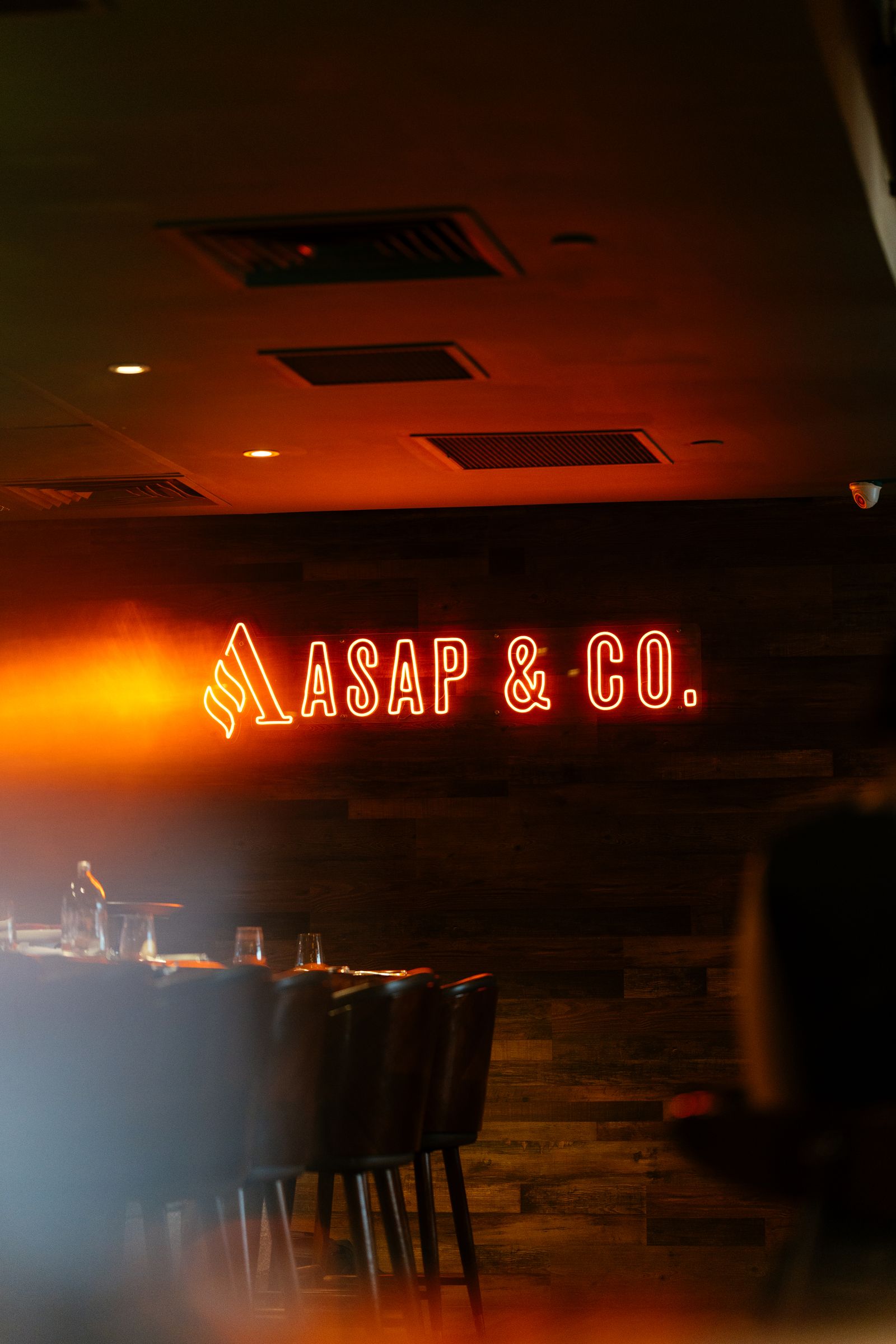 The ASAP & Co. neon sign glowing over the room